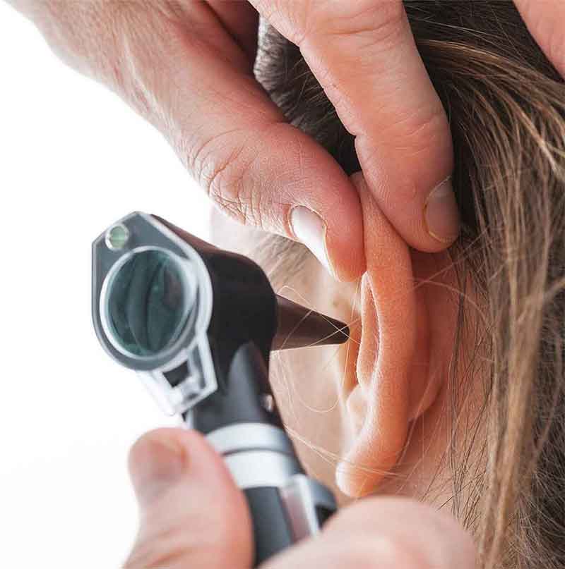 Person having their ears examined to check for hearing loss. 