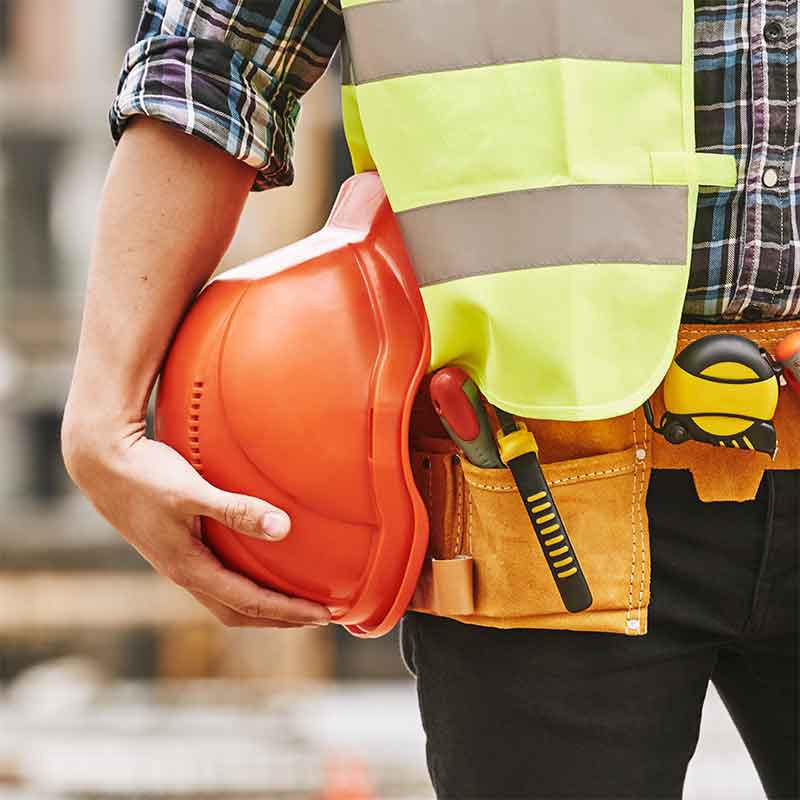 Construction worker holding a hard hat that should also have hearing protection while working